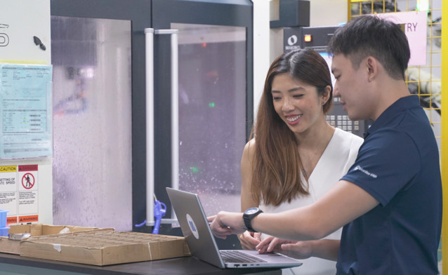 Two people having a discussion in front of a computer