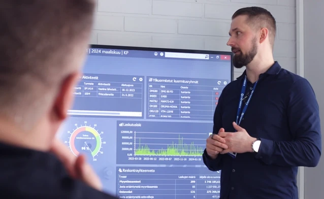 En man som står framför en stor skärm som visar ERP-systemet Monitor ERP.